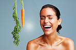 Fresh carrot and young woman laughing against colored background