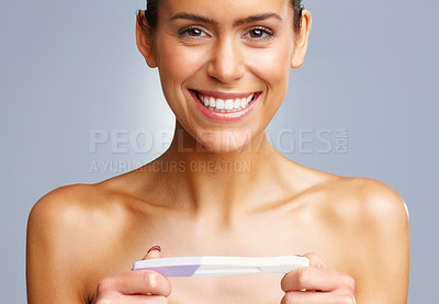 Buy stock photo Closeup portrait of an excited young woman holding pregnancy kit