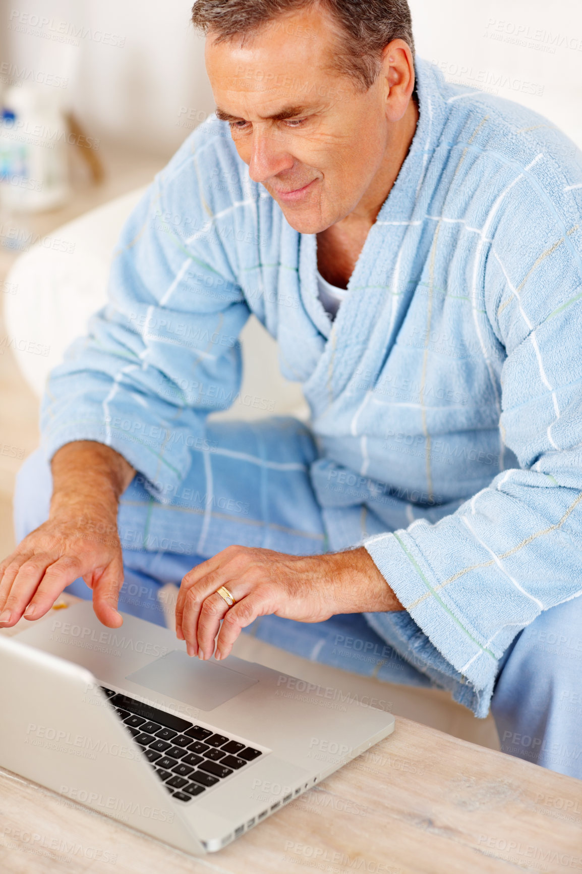 Buy stock photo Bathrobe, morning and mature man on laptop, checking email, social media or streaming subscription on sofa. Internet search, couch and senior person on computer, website or networking in living room.