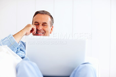 Buy stock photo Bathrobe, relax and sofa, happy man on laptop for email, social media or streaming subscription in home. Internet search, couch and senior person on computer, website or networking in living room.