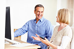 Man and woman calculating expenses with a computer on table