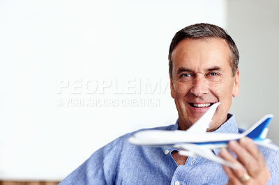 Buy stock photo Mature man, portrait and toy plane fly for travel, vacation and holiday planning with a smile at home. Happy, airplane model and retirement of male person with confidence from trip and air traveling