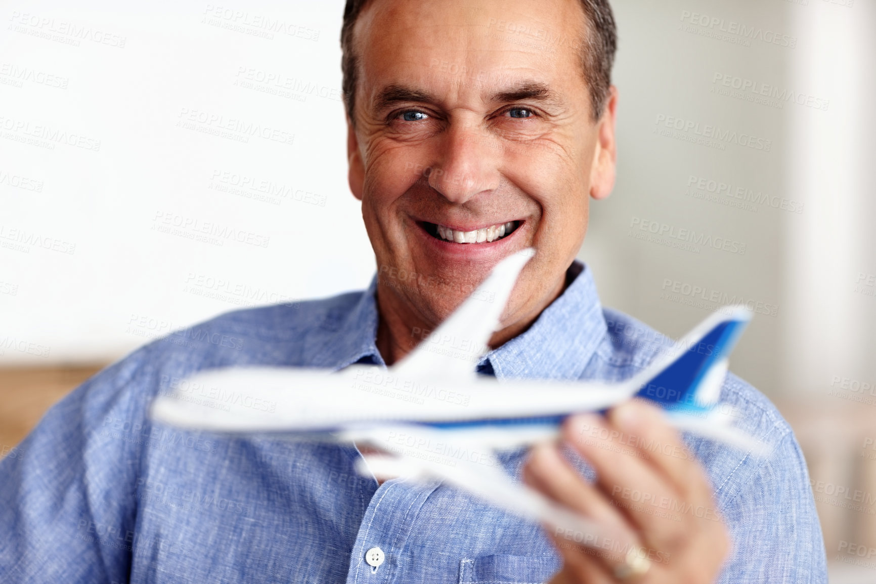 Buy stock photo Mature man, portrait and toy plane for travel, vacation and holiday planning with a smile at home. Happy, airplane model and retirement of a male person with confidence from trip and air traveling