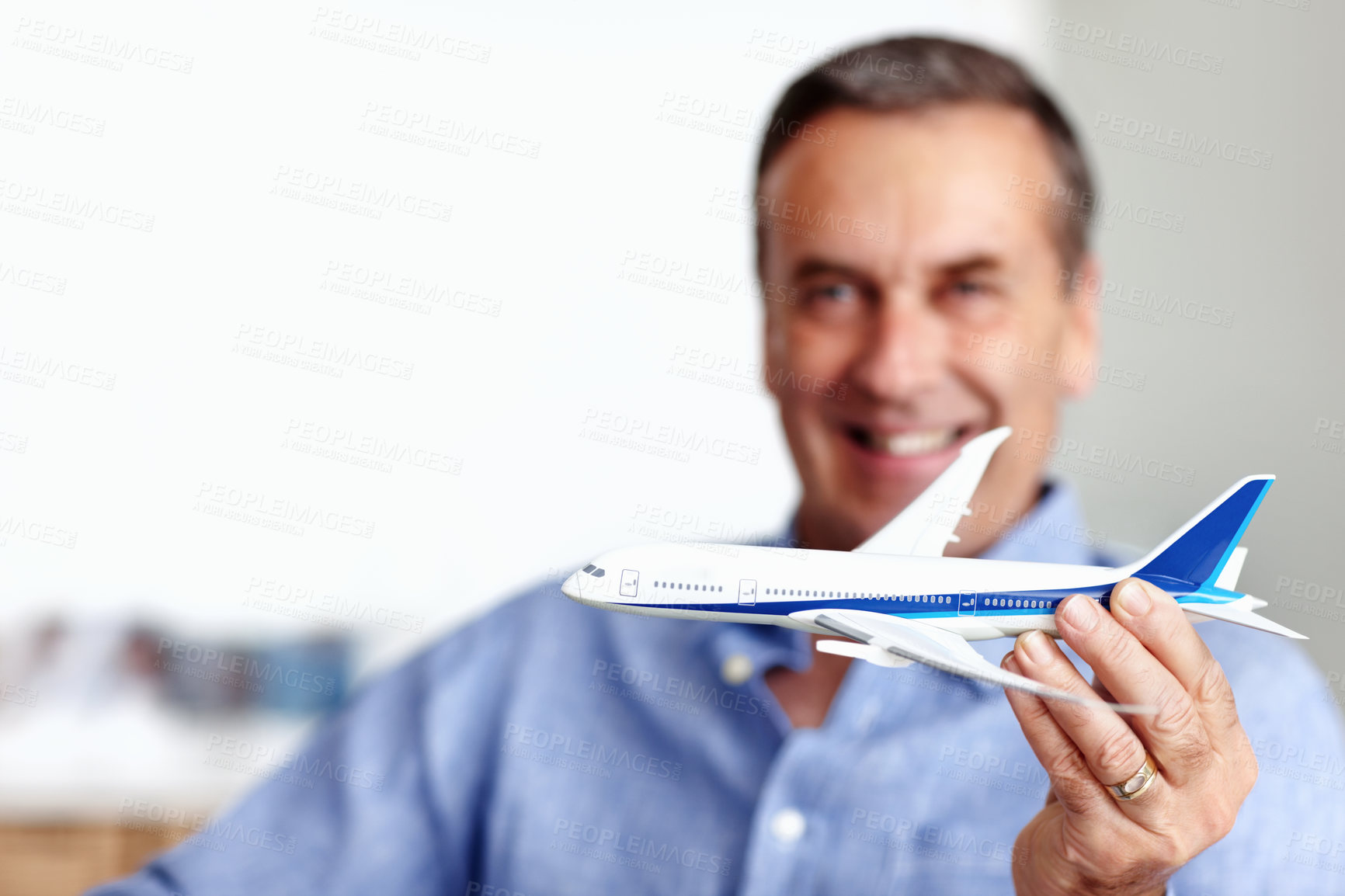 Buy stock photo Mature man, flight and toy plane for travel, vacation and holiday planning with a smile at home. Happy, airplane model and retirement of a male person with confidence from trip and air traveling