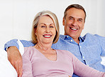 Cheerful mature woman with man sitting against white background