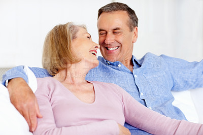 Buy stock photo Senior, couple and face or laughing on sofa with support, relationship and bonding in retirement home. Elderly, man and woman with smile on couch in living room with relax, care and love in house 