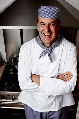 Buy stock photo Portrait of a cheerful senior chef with hands folded standing in front of vent hood
