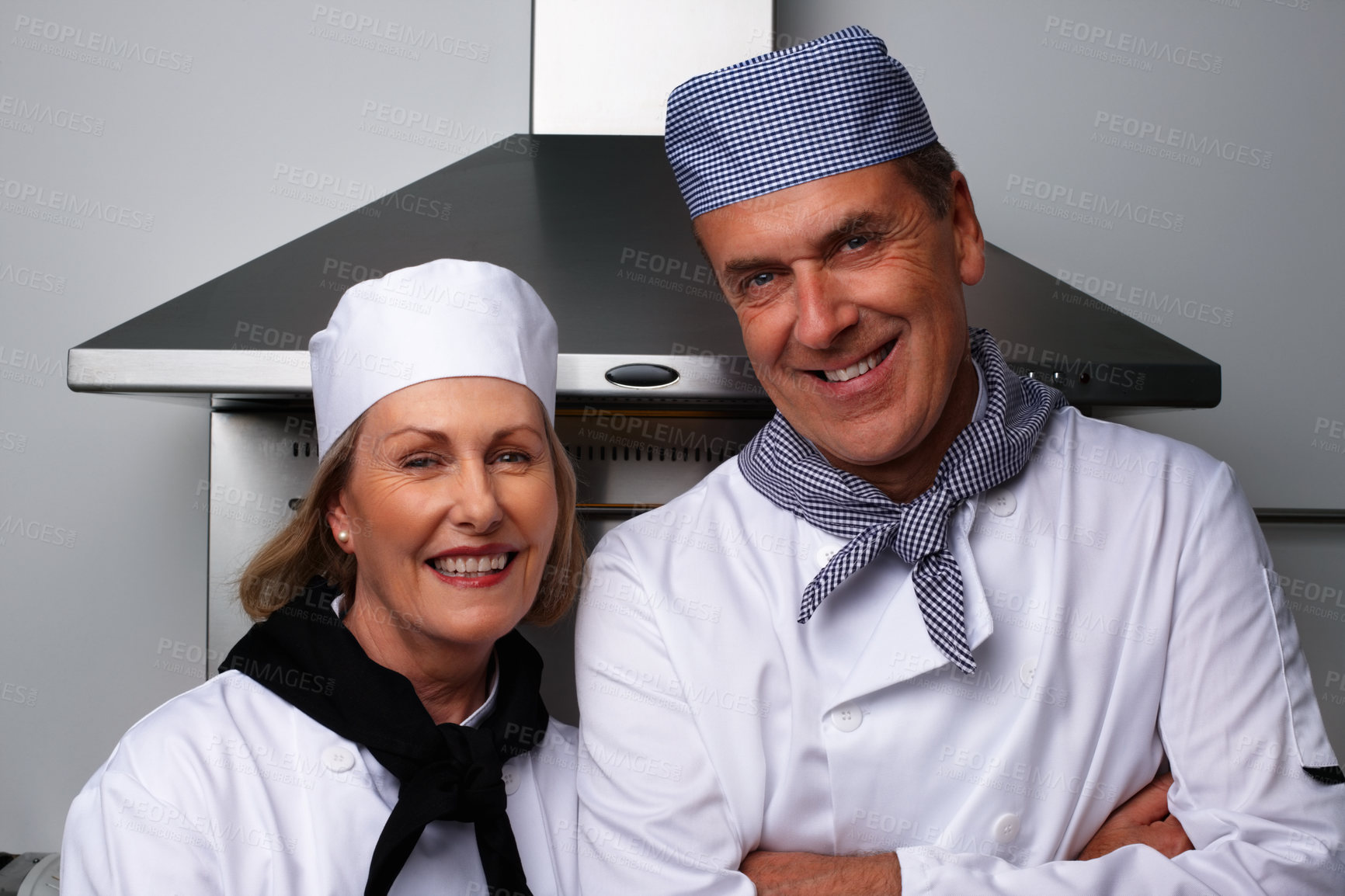 Buy stock photo Portrait of a smiling male and female chefs together standing in the kitchen