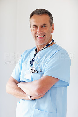 Buy stock photo Portrait of a smiling medical doctor with hands folded against white background