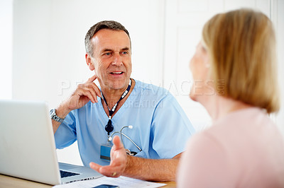 Buy stock photo Portrait of a mature doctor talking with female patient sitting at desk