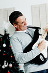 Mature man playing guitar with Christmas tree in background