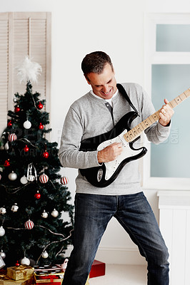 Buy stock photo Electric guitar, mature man and happy for Christmas with gift, excited and fun in living room. Male musician, artist and instrument in lounge for present, creativity and music with happiness at home