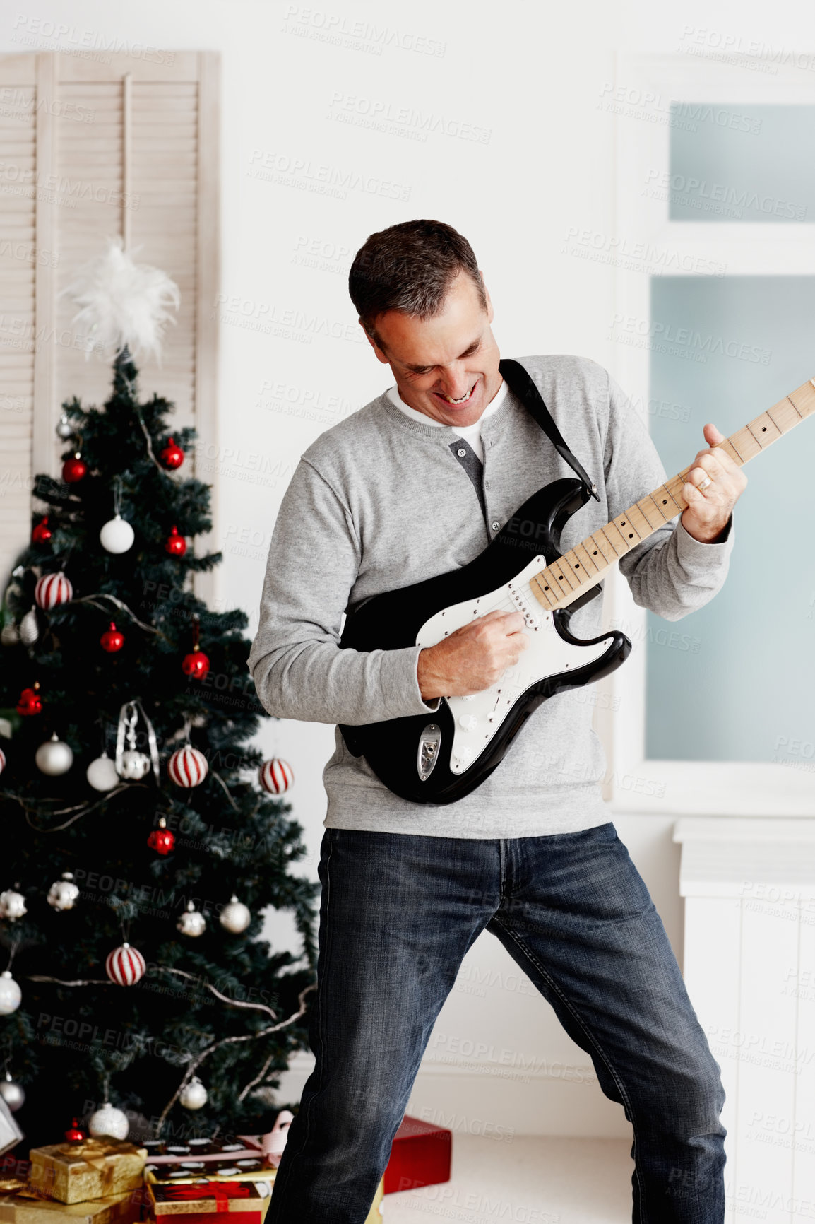 Buy stock photo Electric guitar, mature man and happy for Christmas with gift, excited and fun in living room. Male musician, artist and instrument in lounge for present, creativity and music with happiness at home