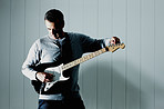 Handsome mature man adjusting an acoustic guitar