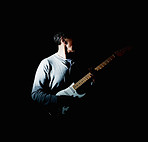 Mature man holding an acoustic guitar against black background