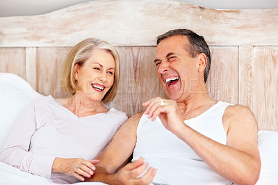 Buy stock photo Mature couple, laugh and hug on bed at house for relax, love and retirement together with trust and care. Man, woman and funny in hotel bedroom for marriage, loyalty or tired on weekend with smile