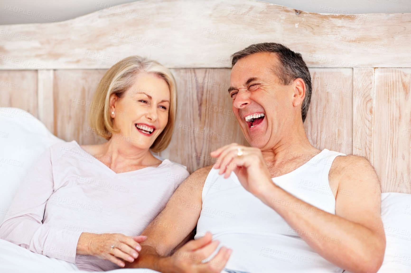 Buy stock photo Mature couple, laugh and hug on bed at house for relax, love and retirement together with trust and care. Man, woman and funny in hotel bedroom for marriage, loyalty or tired on weekend with smile