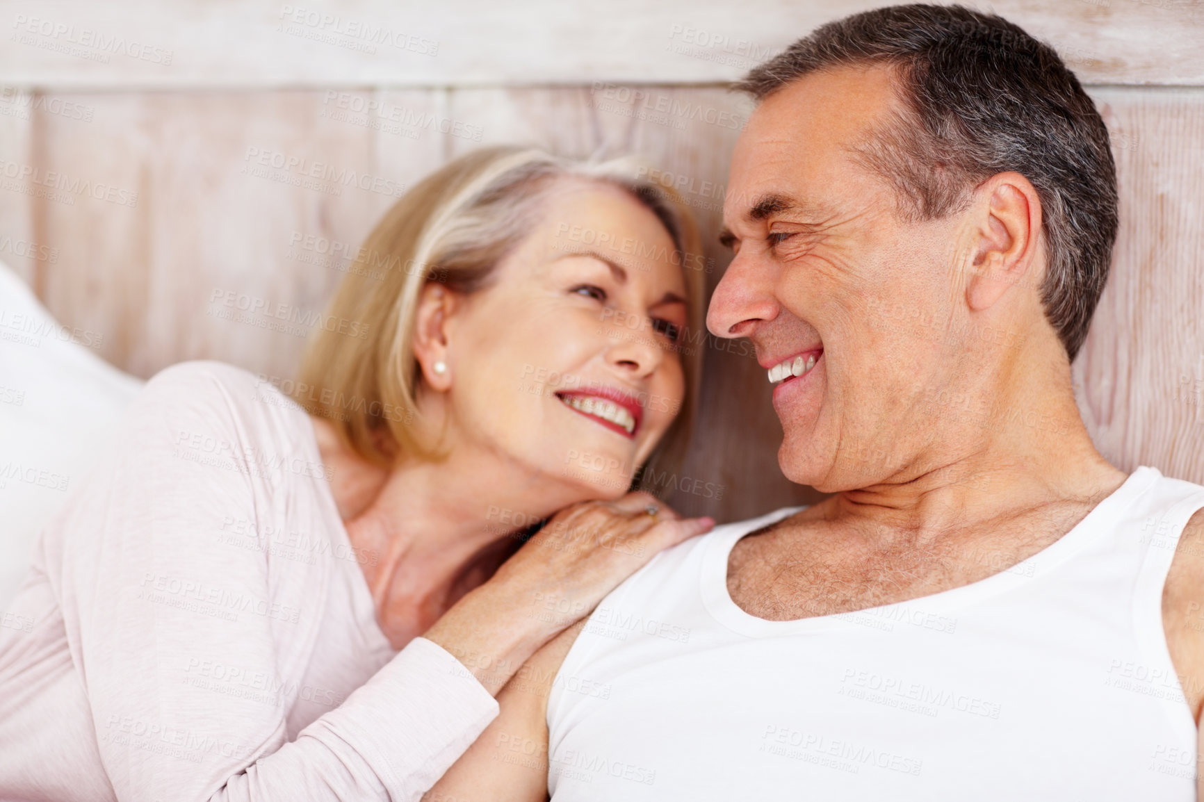 Buy stock photo Closeup portrait of a romantic mature couple looking at each other, smiling