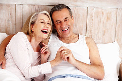 Buy stock photo Mature couple, laugh and funny on bed at house for relax, love and retirement together with trust and care. Man, woman and comedy in hotel bedroom for marriage, loyalty or tired on weekend with smile