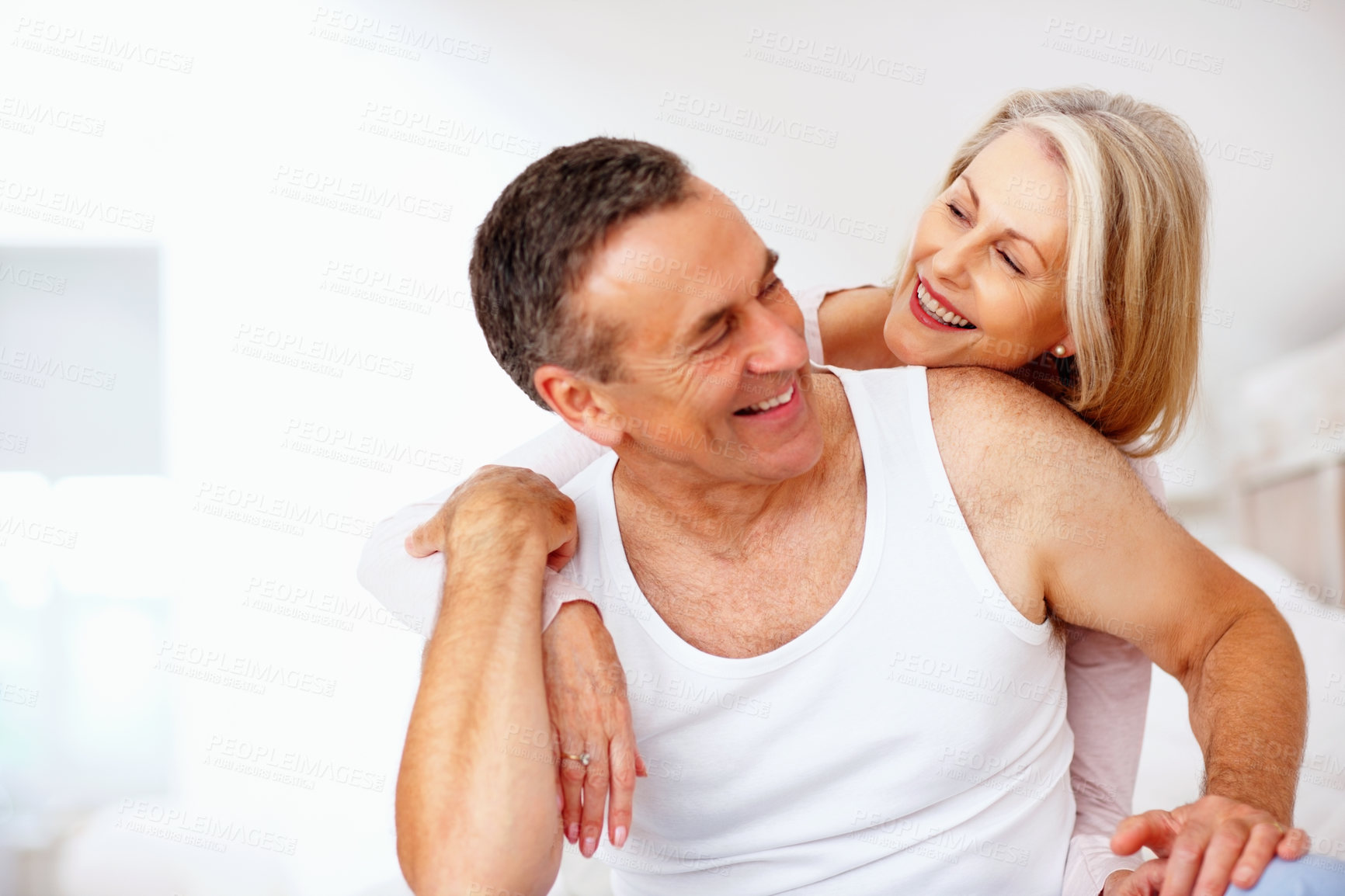 Buy stock photo Mature man, woman and hug on bed at house for relax, love and retirement together with trust and care. Couple, happy and embrace in hotel for marriage, loyalty and anniversary on weekend with smile