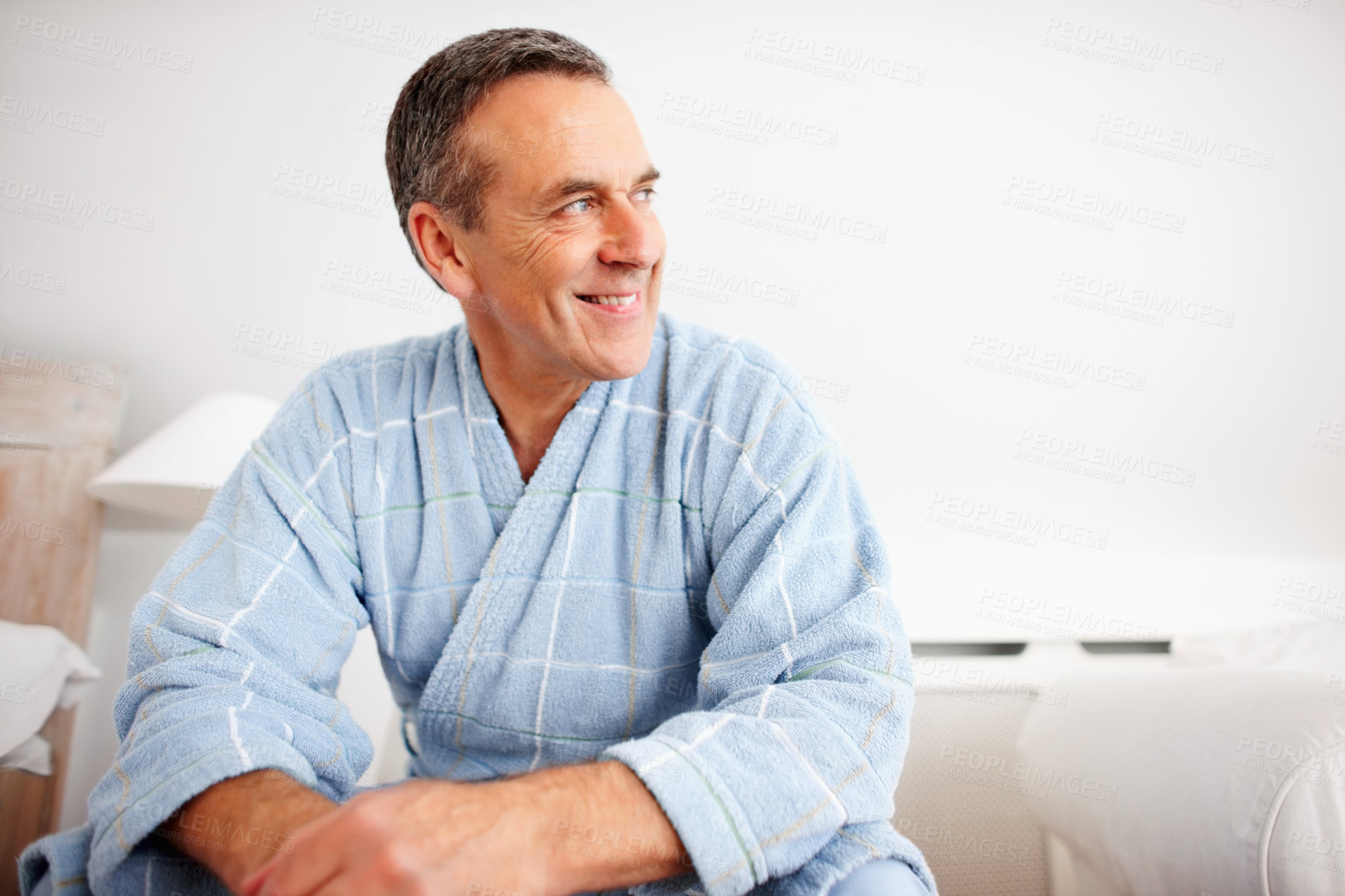 Buy stock photo Closeup portrait of a smiling mature man wearing bathrobe while looking away