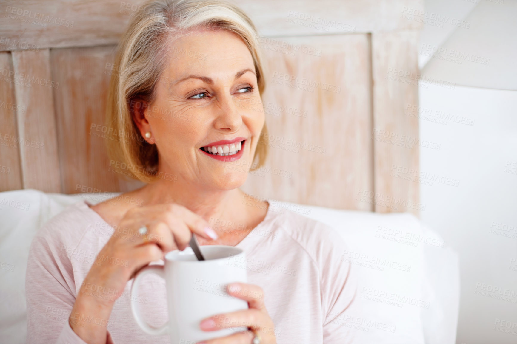 Buy stock photo Closeup portrait of a smiling mature woman stirring tea or coffee while looking away