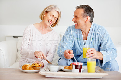 Buy stock photo Mature couple, smile and breakfast together on sofa with bonding, diet nutrition and support in home. Happy, man and woman with morning meal, healthy food and romantic time for love relationship