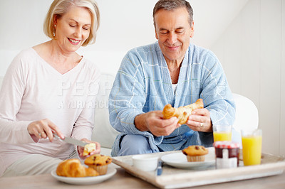 Buy stock photo Mature couple, bedroom and food for diet, breakfast and wellness for retirement health. Senior woman, man and croissant or muffin with fruit juice for romance, nutrition and elderly care or support