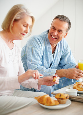 Buy stock photo Senior couple, bedroom and food for diet, breakfast and wellness for retirement health. Mature woman, man and croissant or muffin with fruit juice for romance, nutrition and elderly care or support