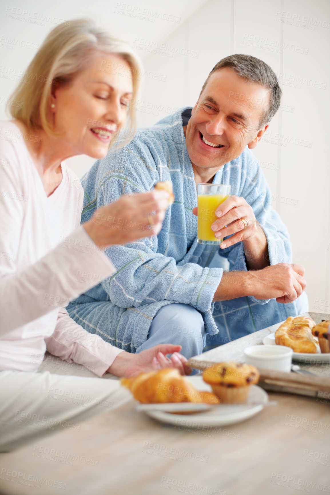 Buy stock photo Portrait of a cheerful mature man and woman having breakfast at home