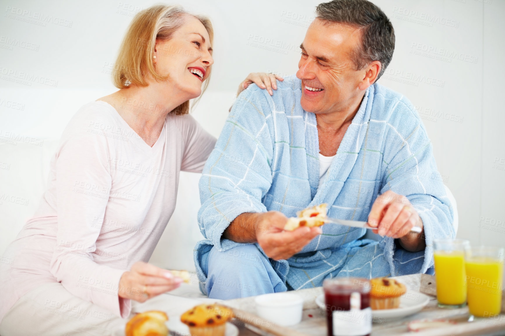 Buy stock photo Mature couple, bedroom and food for wellness, breakfast and nutrition for retirement health. senior woman, man and croissant or muffin with fruit jam for diet, romance and elderly care or support