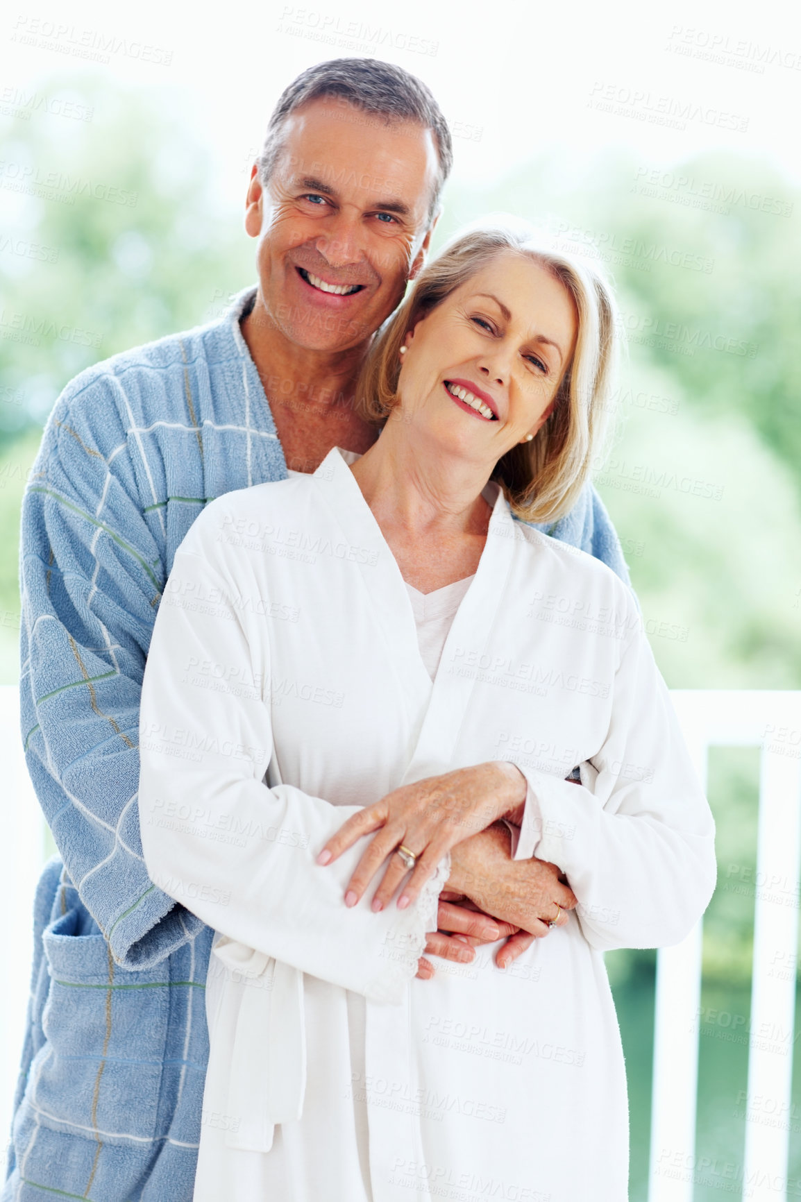 Buy stock photo Portrait, hug and window with mature couple, love and support in living room of house together. Smile, face and trust with happy, senior man and woman bonding while enjoying retirement at home