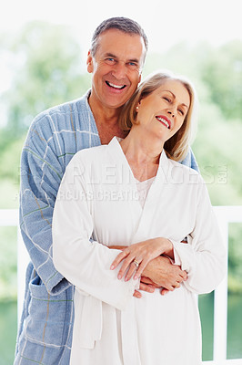 Buy stock photo Portrait, support and balcony with mature couple, love and hug in living room of house together. Smile, face and trust with happy, senior man and woman bonding while enjoying retirement at home