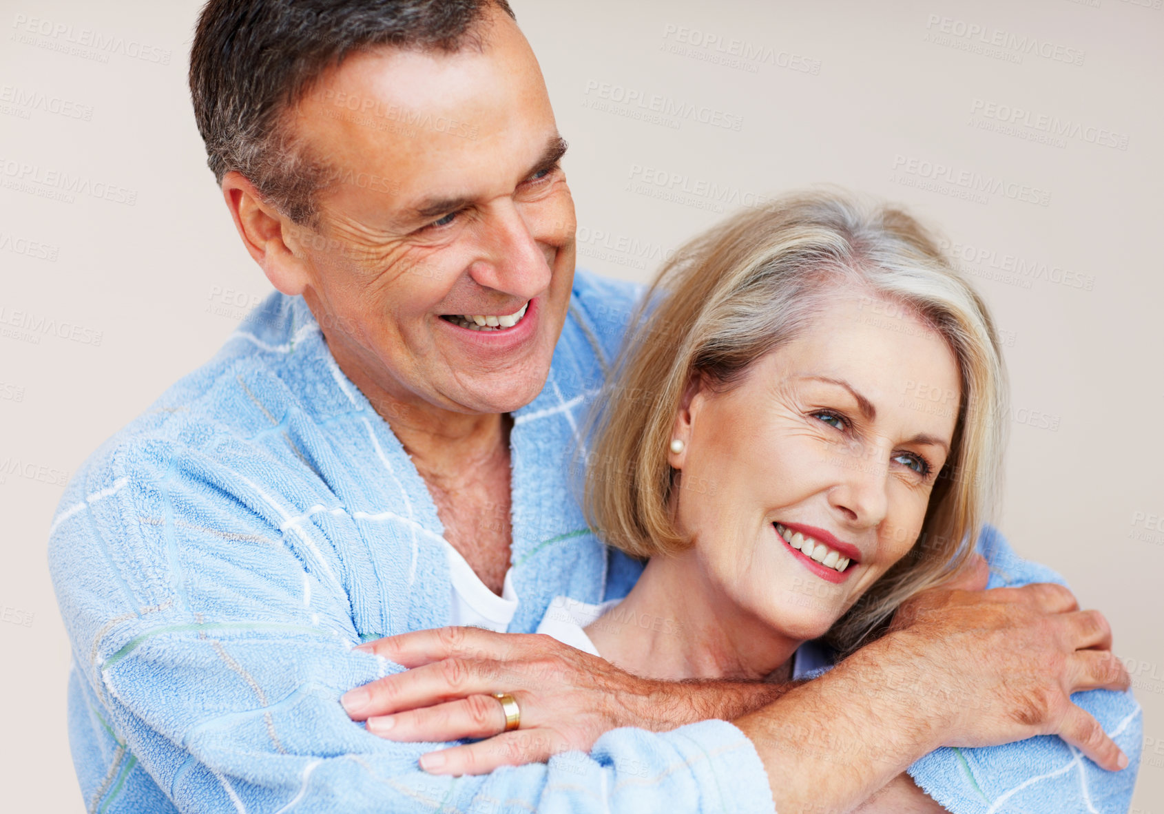 Buy stock photo Mature couple, hug and bonding in home with love for retirement, leisure and wellness in gown. Man, woman and comfort in house for peace, health and relax with smile, happiness and stress relief