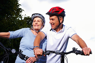 Buy stock photo Mature couple, helmet and bicycle in park for hobby, portrait or smile on weekend for exercise. Fitness, cardio or bike with safety hands for workout and health, cycling or married people for sport