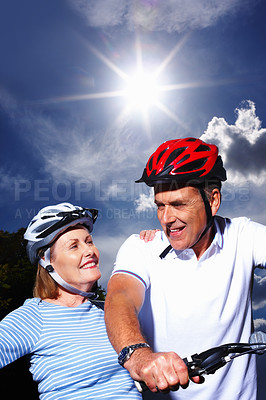 Buy stock photo Portrait of mature couple with bicycle and protective helmet on a sunny day