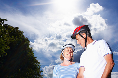 Buy stock photo Mature couple, helmet and blue sky for hobby, trees and smile for weekend exercise. Fitness, cardio and bike with safety wear for workout and health, cycling and retired married people for sport