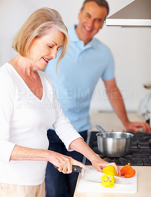 Buy stock photo Senior, couple and woman in kitchen for cooking with food preparation, dinner meal and vegetables for nutrition in home. Elderly, people and happy with cutting peppers ingredients for healthy lunch