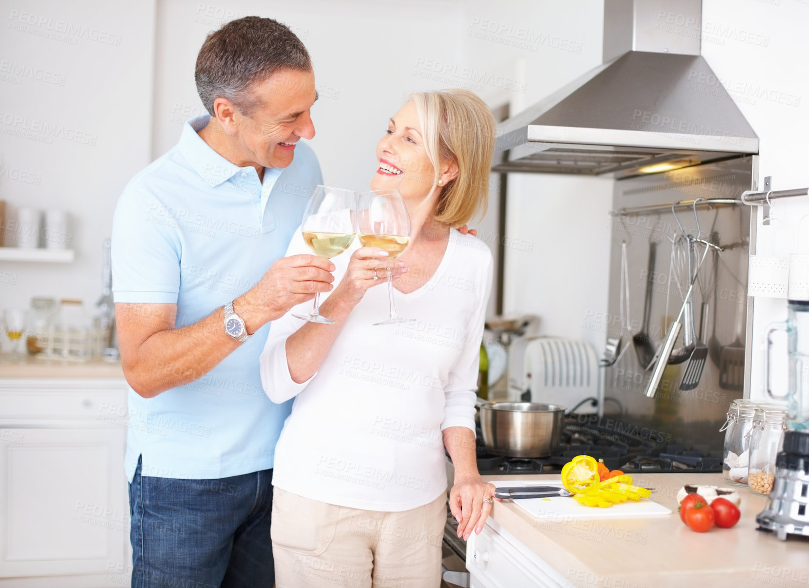 Buy stock photo Happy couple, senior and wine with toast at dinner, meal and nutrition as romantic partner. Mature people, cooking and kitchen with bonding, relationship and together in home for diet, health or love