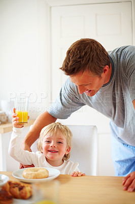 Buy stock photo Kid, breakfast and dad care at home in the morning with food, love and happy from eating. Family, dinner table and hungry young child with father with support together in a house with orange juice