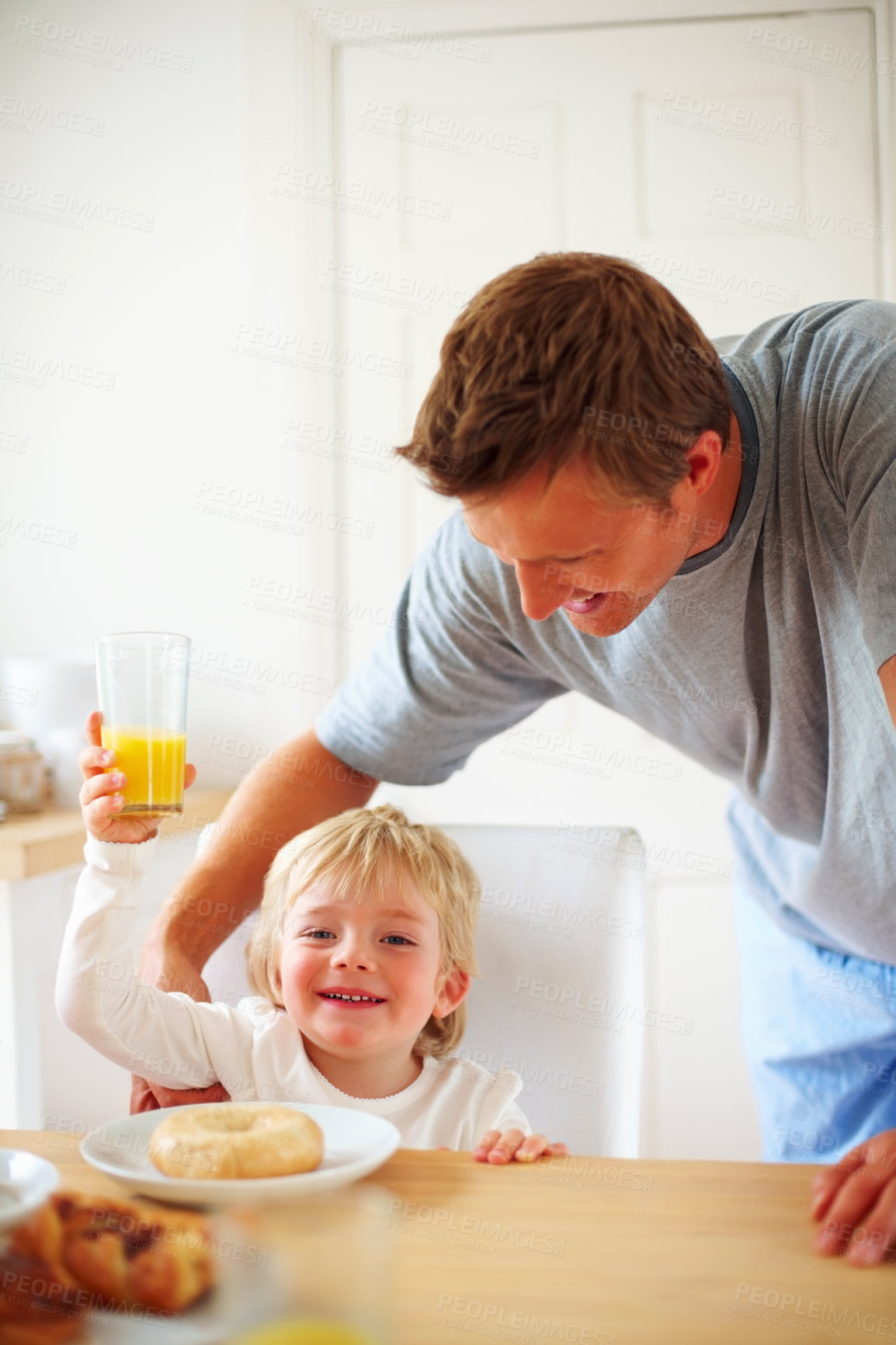 Buy stock photo Kid, breakfast and dad care at home in the morning with food, love and happy from eating. Family, dinner table and hungry young child with father with support together in a house with orange juice