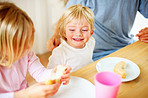 Smiling little boy with his family having breakfast