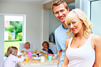 Mature couple with their children having breakfast in background