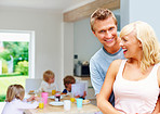 Mature couple with their children having breakfast in background