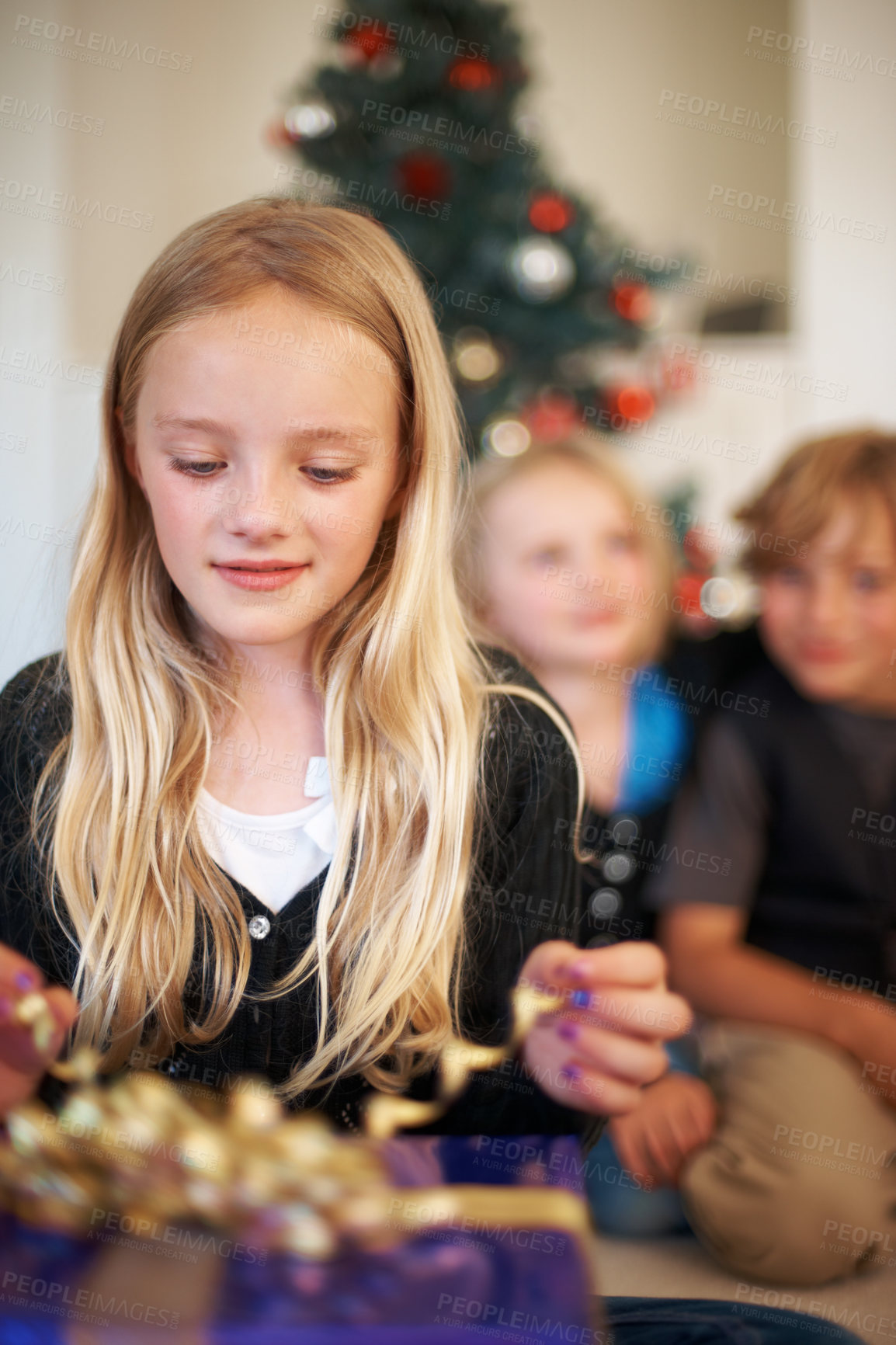 Buy stock photo Girl, gift or unwrap ribbon in festive season with happiness, christmas tree or excited siblings in living room. Children, surprise or smile for presents in house, together or celebration on holiday