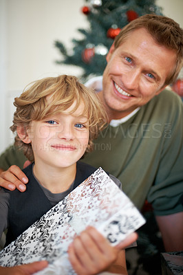 Buy stock photo Boy, gift and father in portrait for festive season sharing, love together and excited in living room. Child, man and smile face for presents in house, bonding and celebration with care on holiday