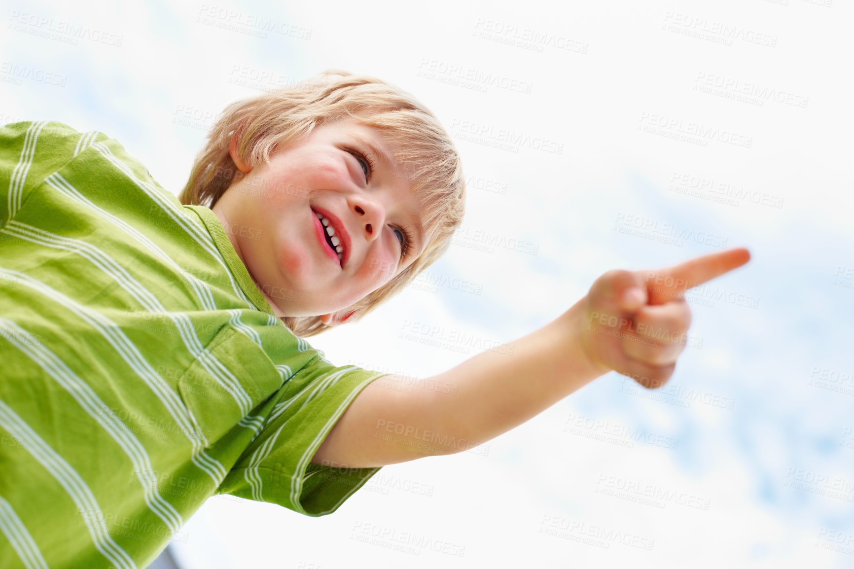 Buy stock photo Boy, happy child and pointing at blue sky outdoor in low angle, summer mockup and show direction. Young cute kid, finger and hand gesture at clouds, playing and freedom for education below with smile