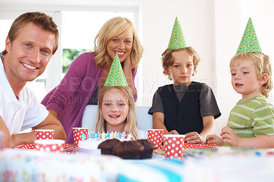 Buy stock photo Birthday, party and a family in their home together for the celebration of a milestone with children. Smile, love or a happy mother, father and sibling kids in the living room for an event with cake