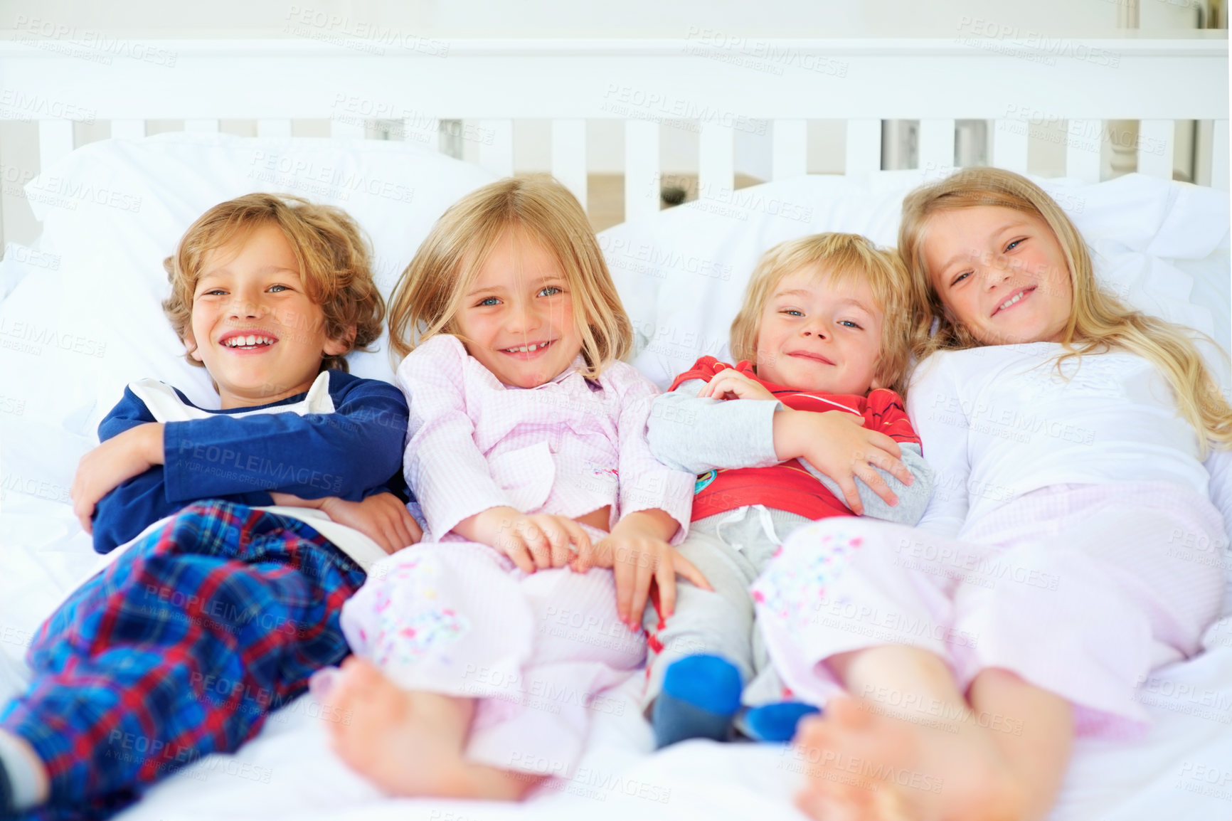 Buy stock photo Portrait, brothers and sisters together on bed with relax wellness, happiness and sibling support in home. Boys, girls and smile face in morning in pyjamas, family bonding and love with care in house