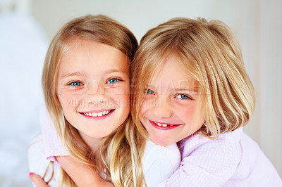 Buy stock photo Portrait, sisters and hug indoors with love for relax wellness, happiness and sibling support in home. Children, girls and smile face for fun morning in embrace, family and bonding for care in house